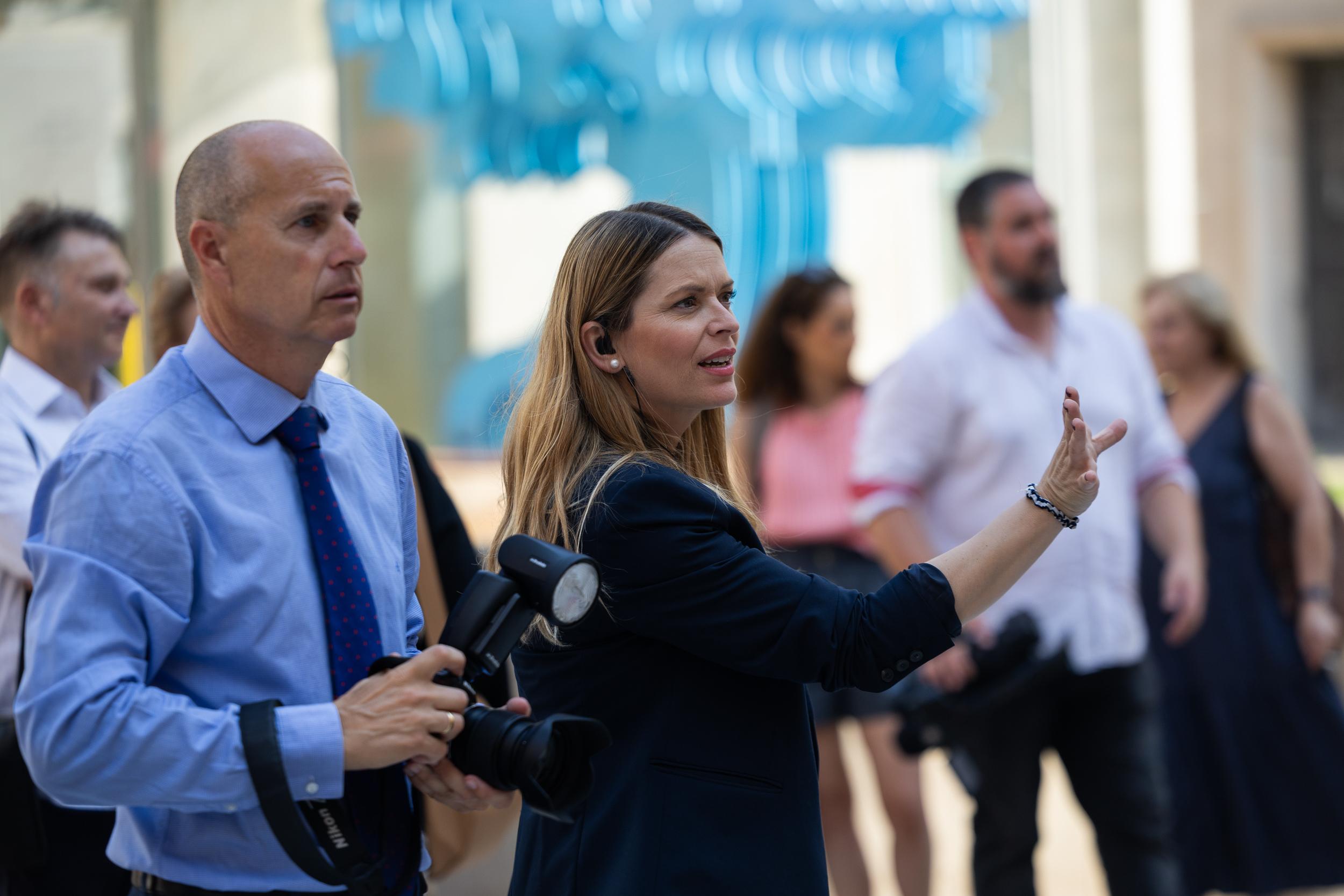 Coordinación de protocolo durante un acto institucional con asistentes y equipo profesional