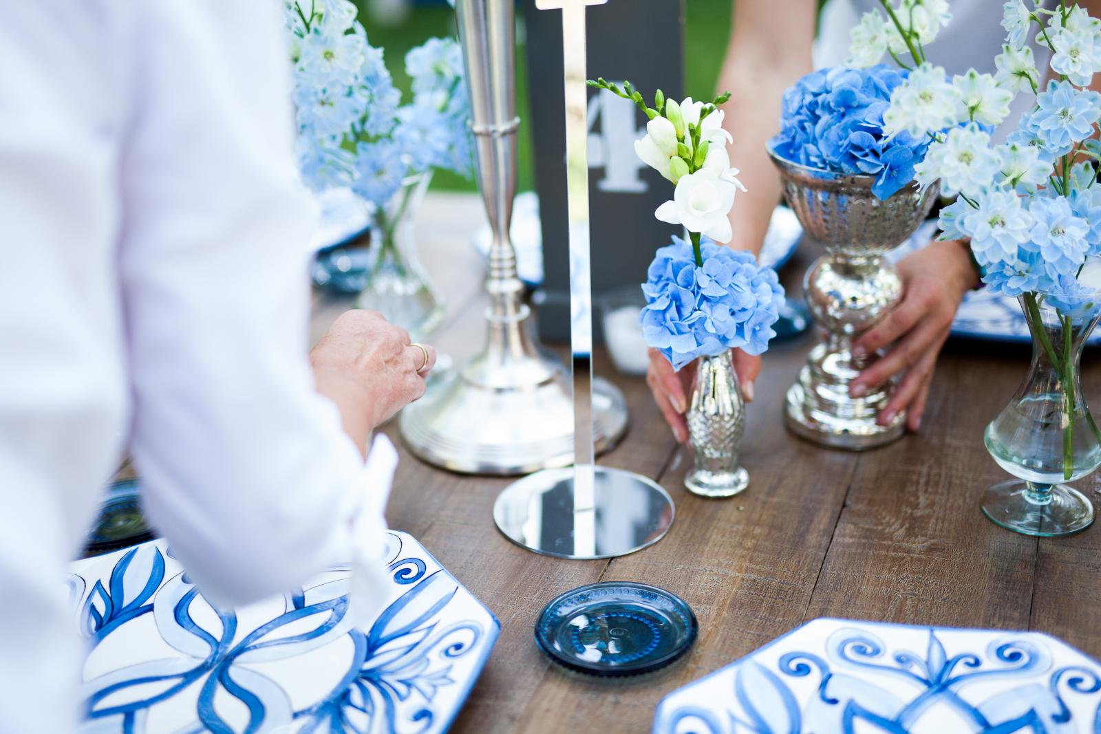 Detalle de montaje de mesa para evento con decoración floral y elementos protocolarios