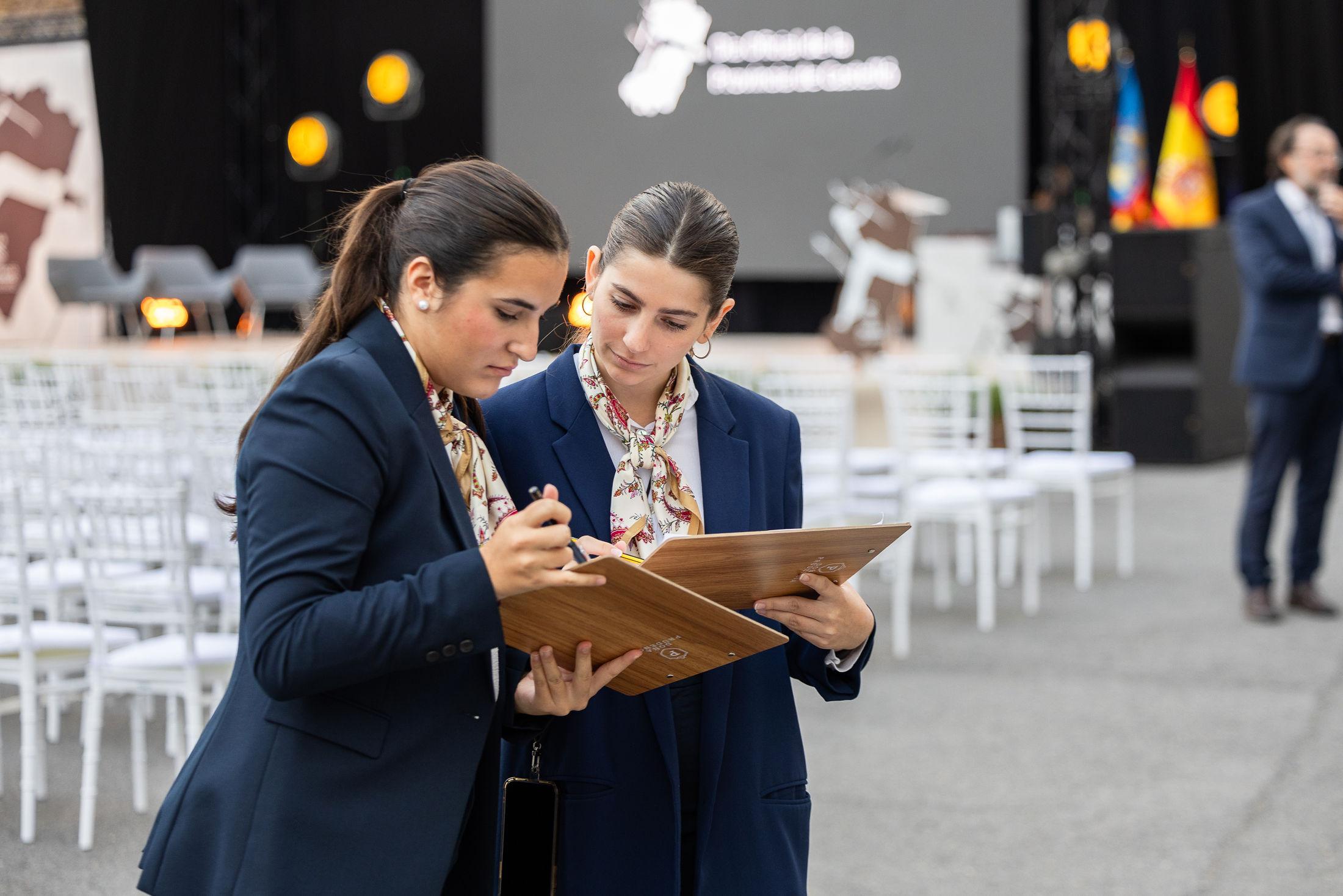 Personal de apoyo gestionando documentación y atención durante un evento